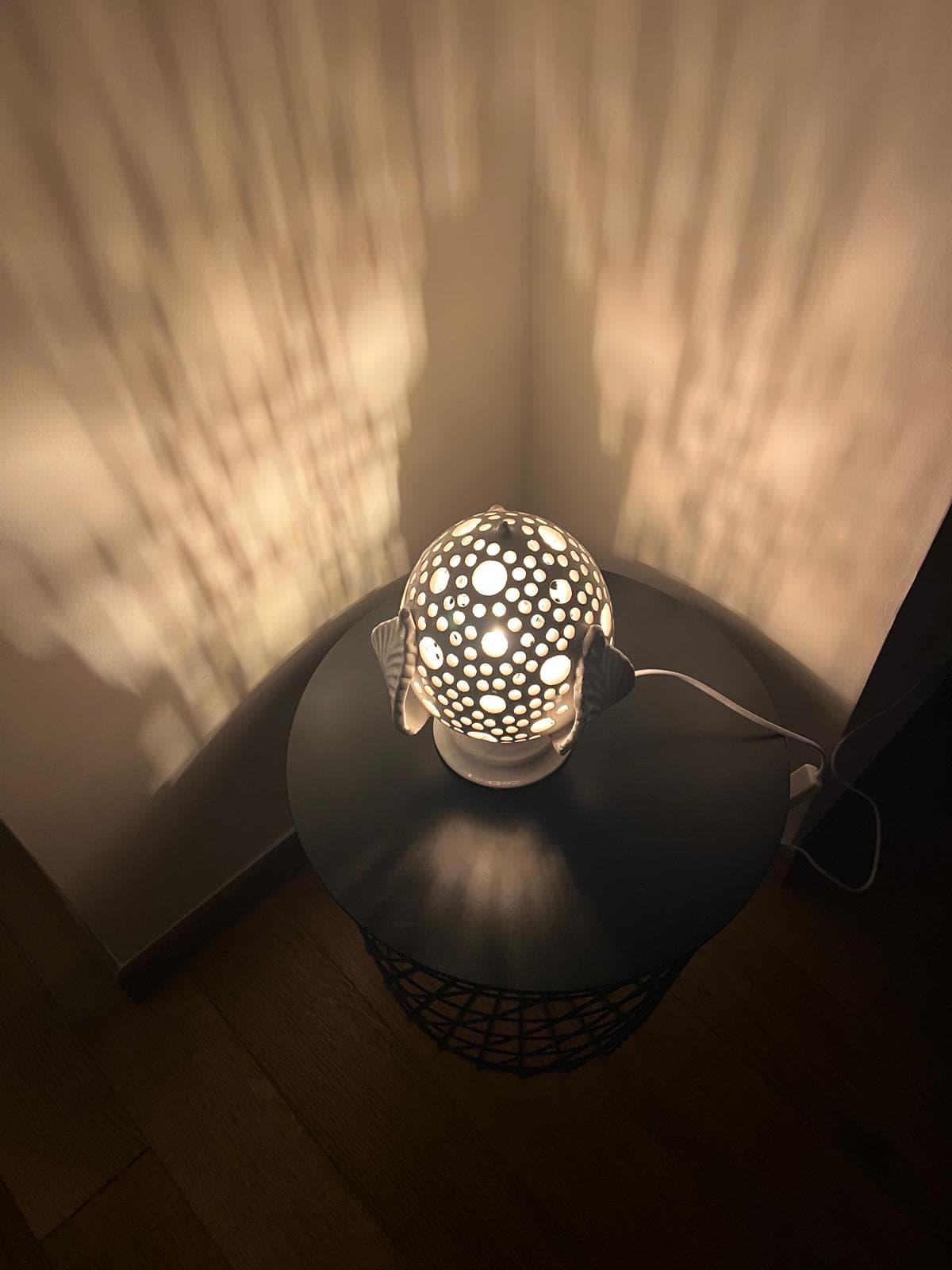 Lampada in ceramica traforata che proietta luce calda